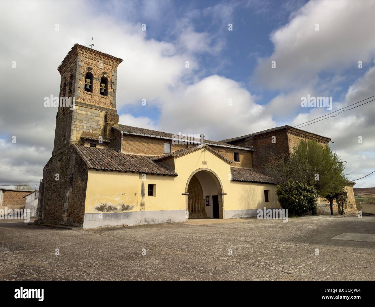 Rustikale romanische Kirche mit gemischtem Mauerwerk und Ziegelwerk in einem ruhigen Dorf Stockfoto