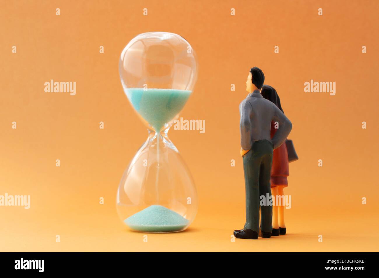 Paare, die die Zeit beobachten, vergehen in einer Sanduhr Stockfoto