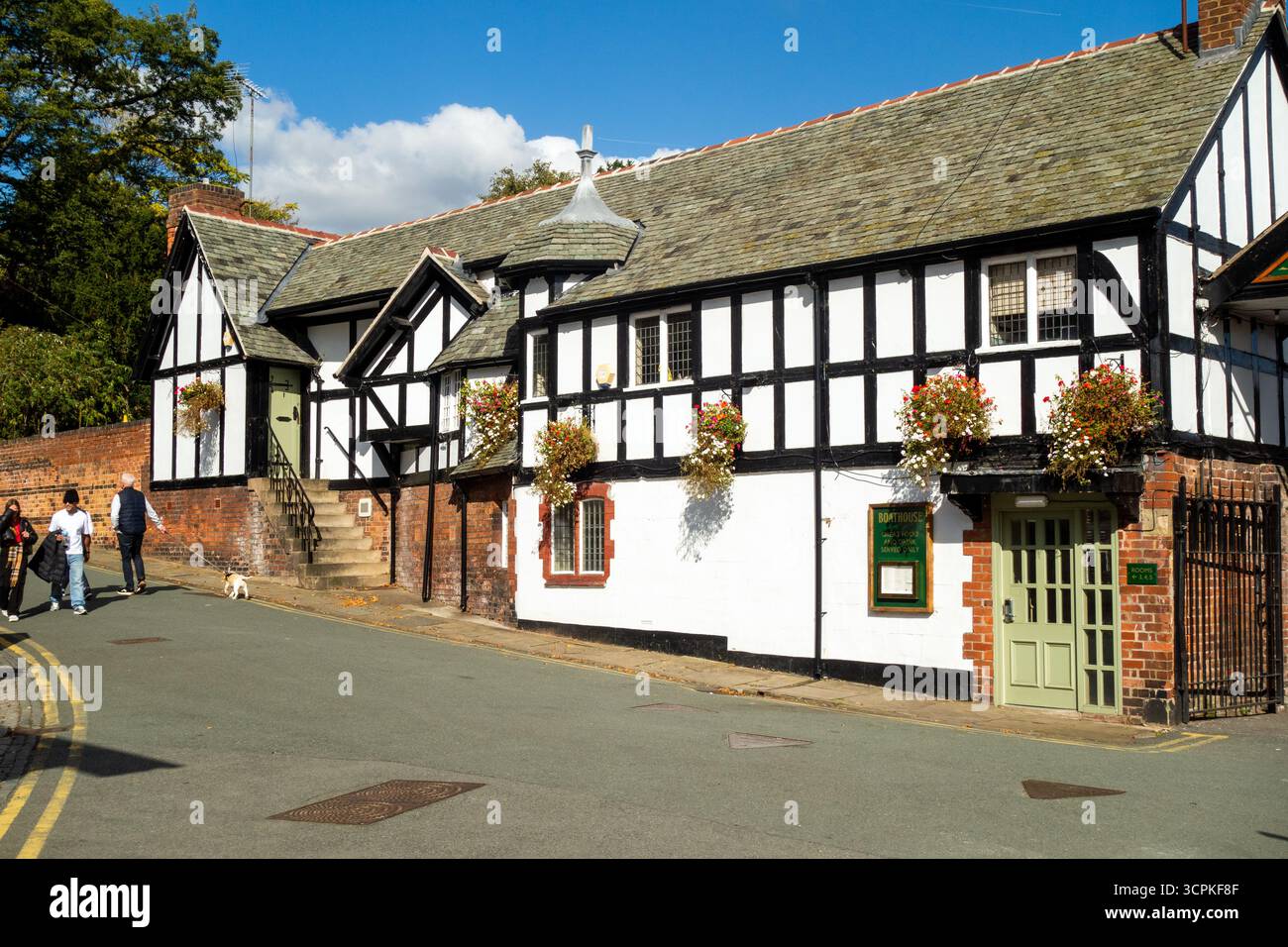 Leute, die an dem Bootshaus Pub und dem Zimmer am Fluss in Cheshire County und der Stadt Chester, England, vorbeilaufen Stockfoto