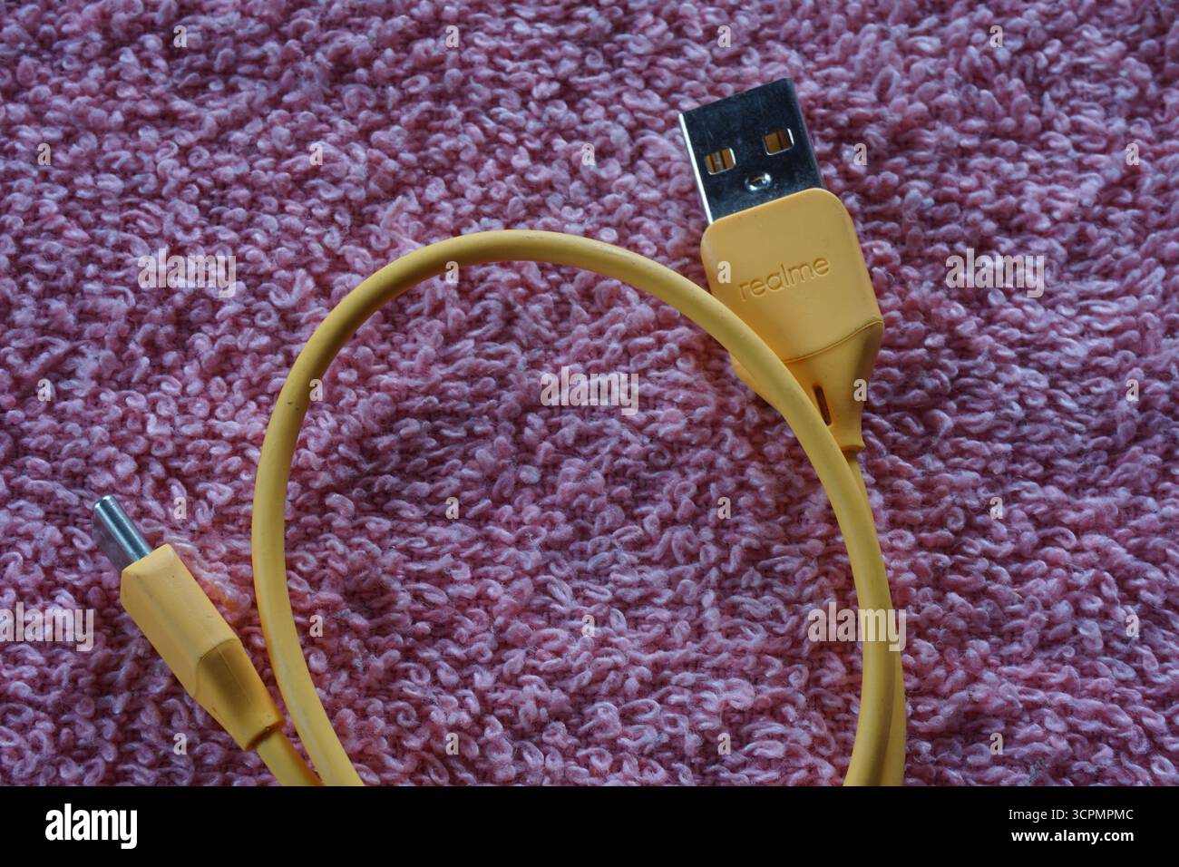 Gelbes realme usb Typ-C-Kabel auf rotem Hintergrund. Realme usb-Ladekabel. Stockfoto