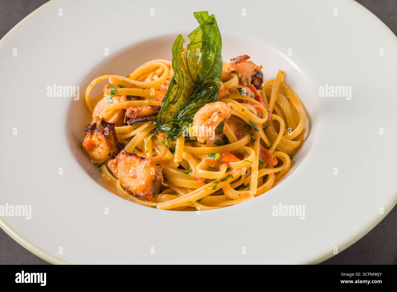 Linguine-Pasta mit Garnelen und Meeresfrüchten in Tomaten- und Knoblauchsoße Stockfoto