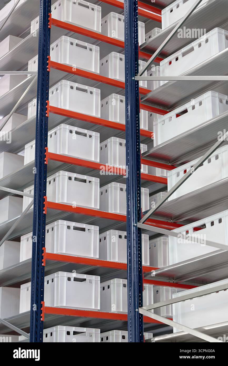 Generische weiße unbeschriftete Kisten und Kisten auf Regalen eines Lagerregals, abstrakter industrieller Hintergrund Stockfoto