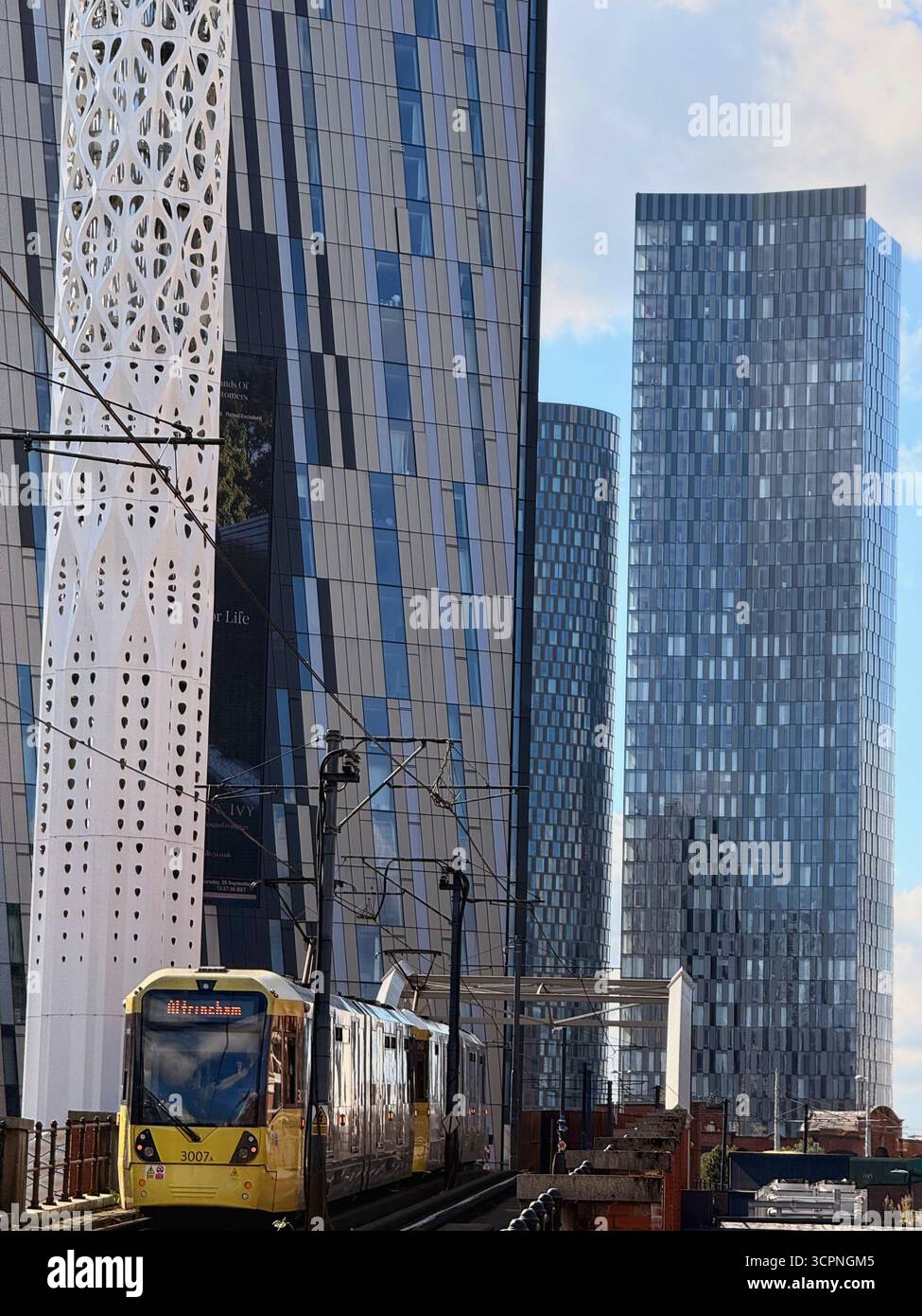 Gelbe Straßenbahn und Wolkenkratzer des Deansgate Square Complex im Stadtzentrum von Manchester - Smartphone-aufgenommenes Stockfoto