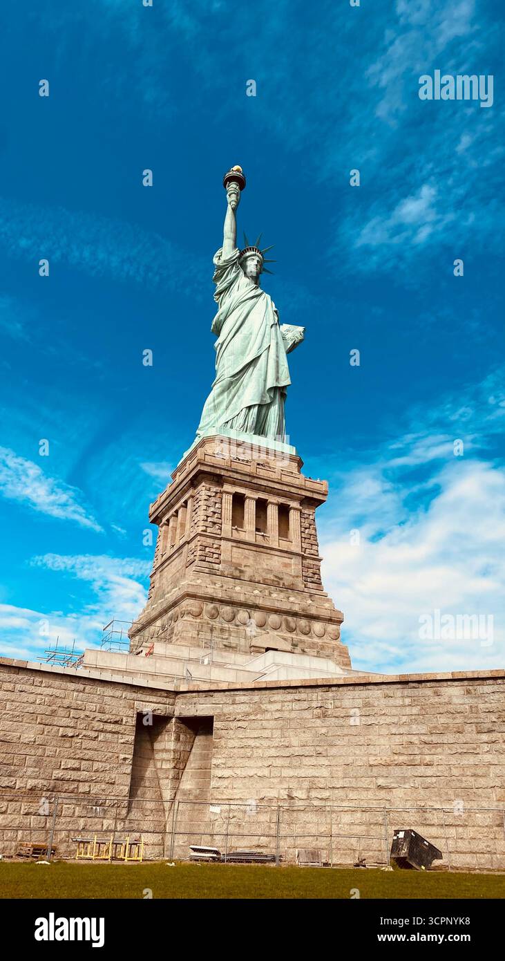 Freiheitsstatue gegen Blauen Himmel mit verstreuten Wolken in New York City - Smartphone-aufgenommenes Stockfoto