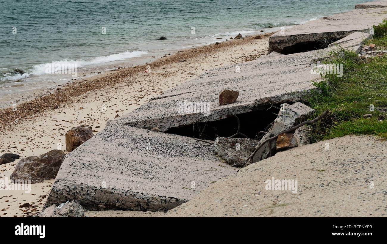 Erodierte Küstenstraßeninfrastruktur stürzt durch Meereswellen und Sturmeinwirkungen zusammen. Stockfoto