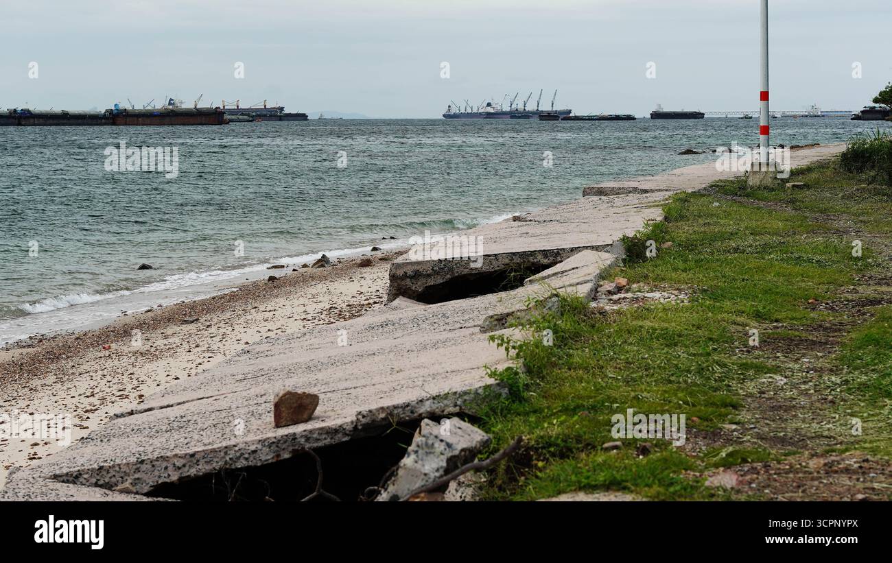 Sturmflut und Meereswellen zerstören die Küstenstraße und -Infrastruktur aus Beton. Stockfoto