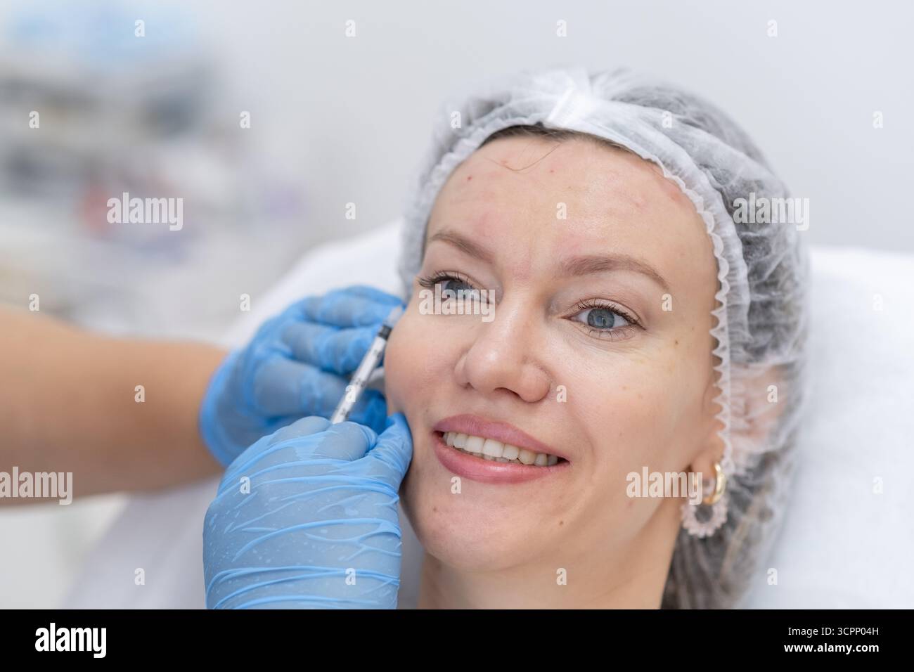 Ein Patient erhält eine Botulinumtherapie mit einem qualifizierten Arzt in einer modernen Klinik, die ein ruhiges und professionelles Umfeld mit Schwerpunkt auf Hautpflege bietet Stockfoto
