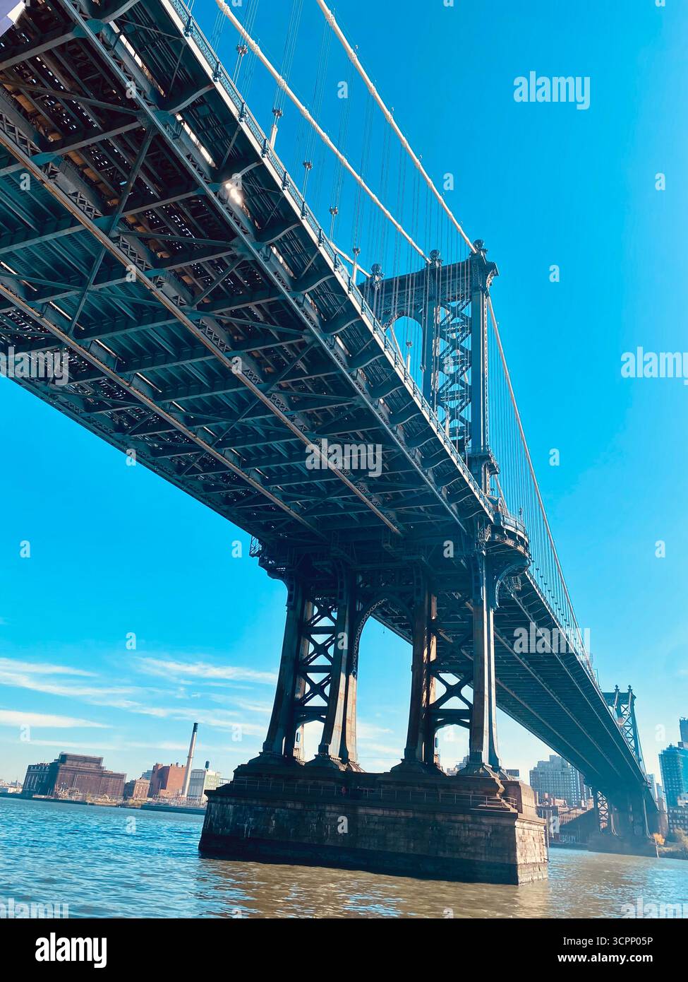 Manhattan Bridge von unten gesehen mit Stahlrahmen und Urban Skyline in New York City - Smartphone-aufgenommenes Stockfoto