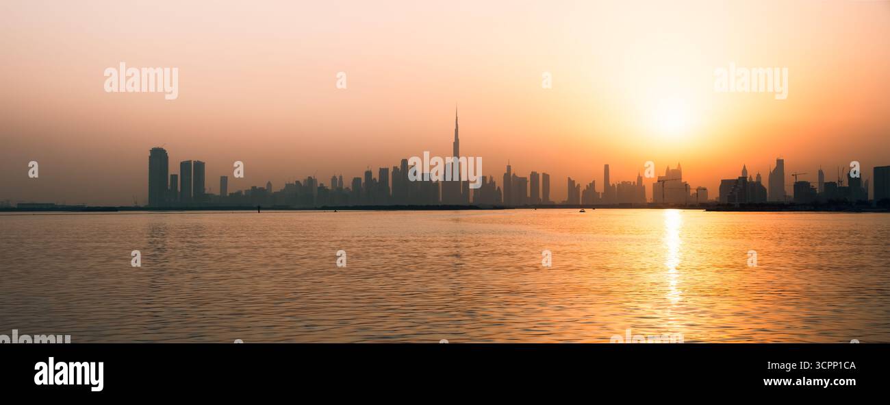 Panoramablick auf die Skyline von Downtown Dubai bei Sonnenuntergang mit Meerblick von der Uferpromenade Creek, horizontale 4K Skyline Hintergrund Stockfoto