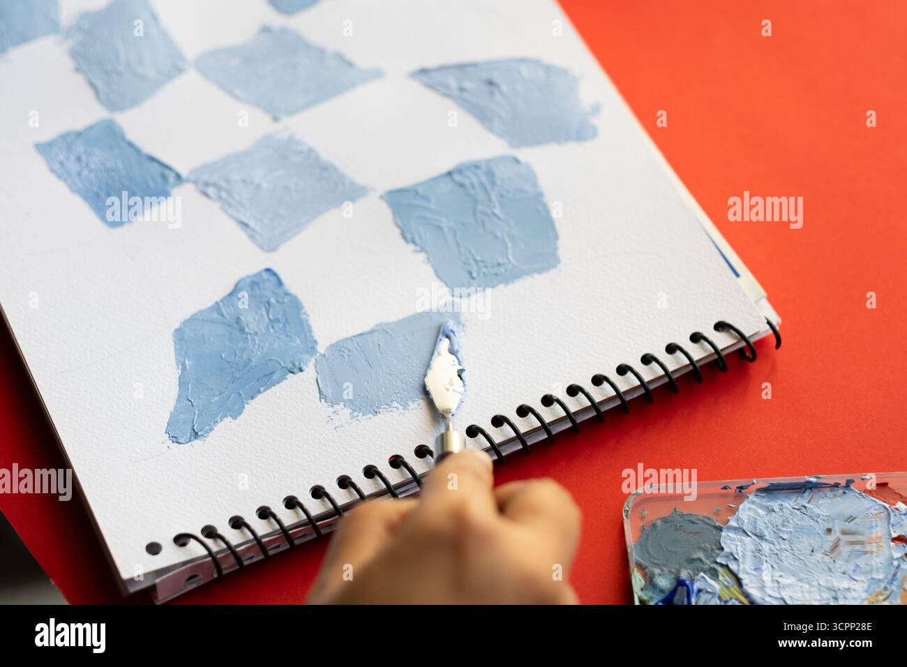 Acrylfarbe mischen mit Palettenmesser, Künstler erstellen strukturierte Muster auf Skizzenbuch für Kunstprojekt, Pastell Farben strukturierte Kunst auf weißer Dose Stockfoto