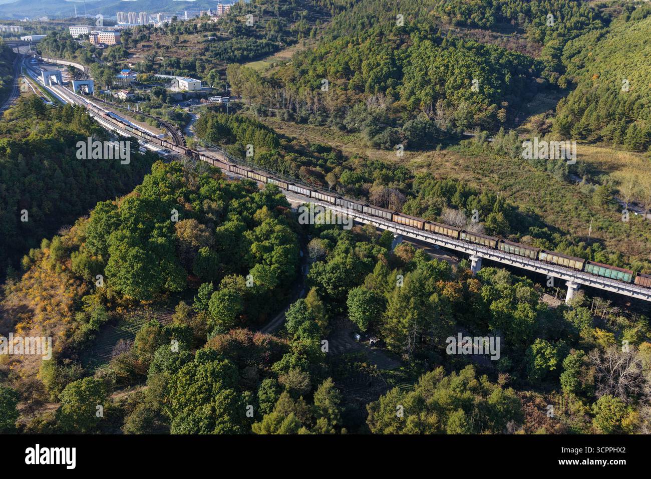 Suifenhe. September 2025. Ein Luftdrohnenfoto vom 27. September 2025 zeigt einen Güterzug, der entlang des neu ausgebauten Abschnitts einer Eisenbahnstrecke fährt, die Suifenhe mit der chinesisch-russischen Grenze in der nordöstlichen chinesischen Provinz Heilongjiang verbindet. Am Samstag wurde ein umfangreicher Ausbau einer Eisenbahnstrecke zwischen Suifenhe und der chinesisch-russischen Grenze abgeschlossen, wobei neue Gleise in Betrieb genommen wurden, die es ermöglichen, mit Geschwindigkeiten von bis zu 120 km/h zu fahren, was mehr als dem Doppelten der bisherigen Grenze von 55 km/h entspricht, wodurch die Transportkapazität erheblich gesteigert wurde. Quelle: Wang Song/Xinhua/Alamy Live News Stockfoto