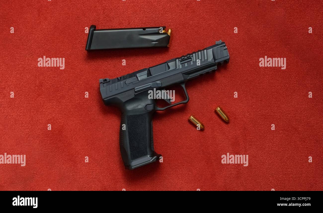 Moderne Pistole mit Munition auf rotem Samtgrund. Idee zur Veranschaulichung von Schusswaffensicherheits- und Sportthemen. Stockfoto