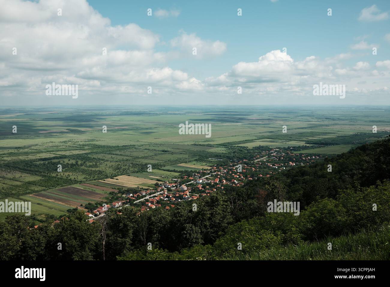 Großer Panoramablick auf Vrsac und die umliegende serbische Landschaft unter einem dramatischen bewölkten Himmel im Frühling. Stockfoto