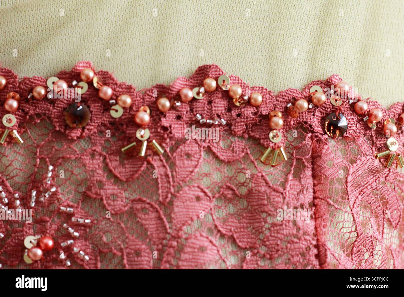 Strukturierter und gemusterter Hintergrund. Roter Brokat. Blumenstickerei mit Perlenperlen. Stockfoto