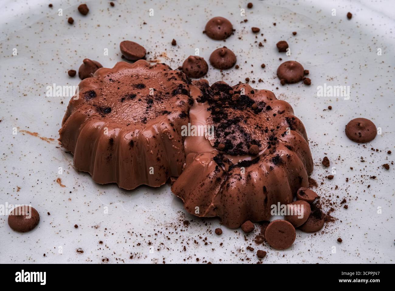 Dieses wunderbare Bild zeigt ein reichhaltiges Schokoladendessert auf einem Teller. Die geschmeidige Textur und das zerbröckelte Topping sorgen für Genuss und Zufriedenheit. Stockfoto