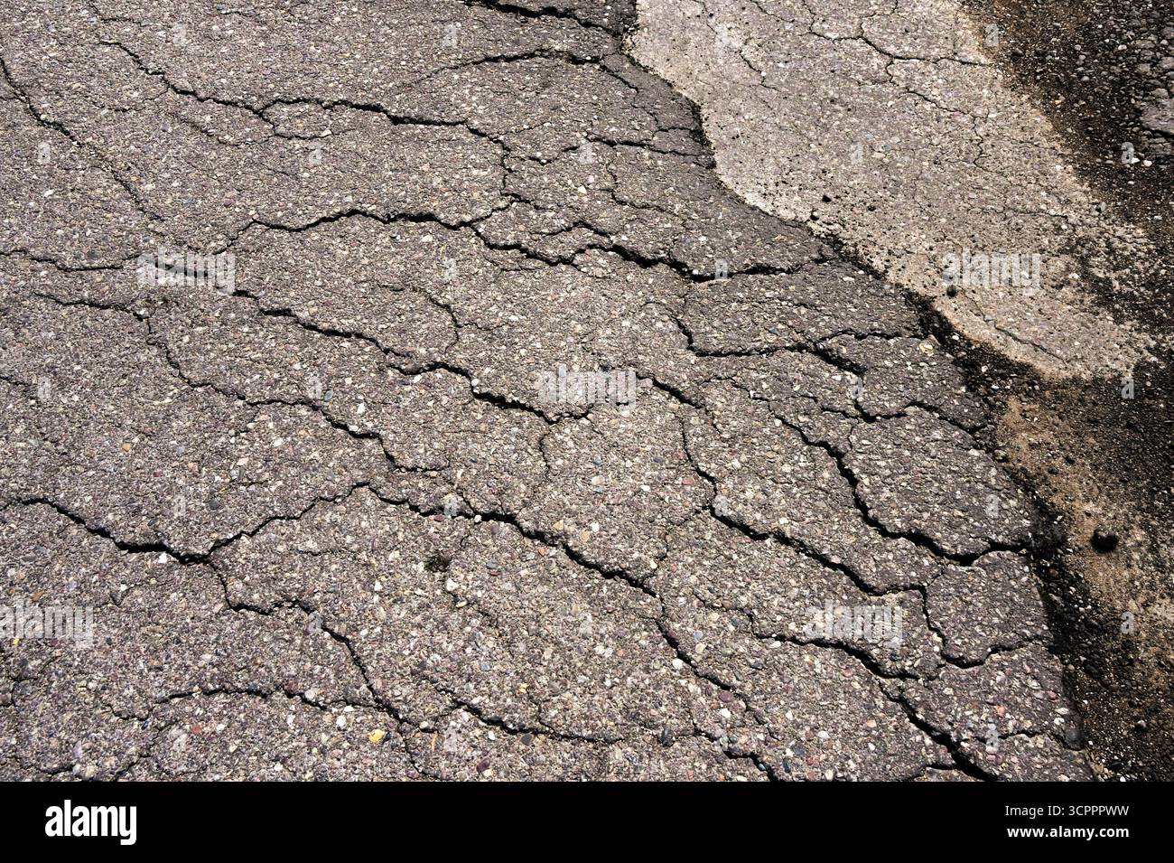 Gebrochene Asphaltplatte und Schlaglöcher auf der beschädigten Straßenoberfläche. Keine Personen. Stockfoto