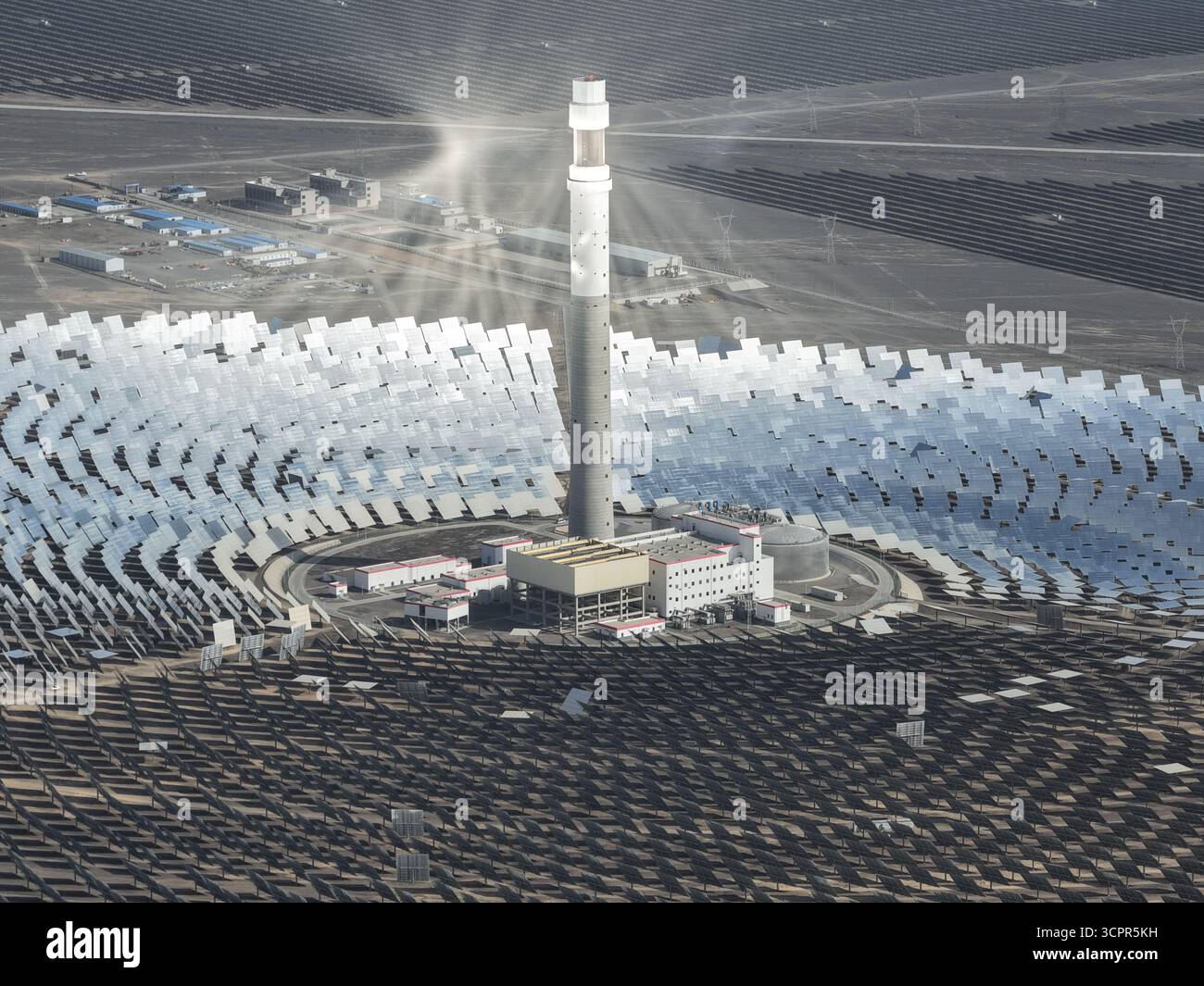 Luftaufnahme der Strahlungsenergie der Sonne, die von den Solarpaneelen rund um den Power Tower reflektiert wird, ein Leuchtfeuer der Innovation gegen die trockene Landschaft, Turpan, Xinjiang, China. Stockfoto Luftaufnahme der Strahlungsenergie der Sonne, die von den Solarpaneelen rund um den Power Tower reflektiert wird, ein Leuchtfeuer der Innovation gegen die trockene Landschaft, Turpan, Xinjiang, China. Stockfoto