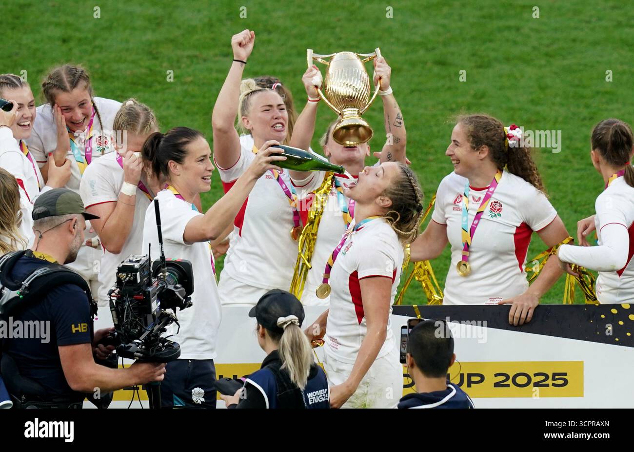 Englands Zoe Aldcroft trinkt aus einer Flasche, während ihre Spieler nach dem Finale der Frauen-Rugby-Weltmeisterschaft im Allianz Stadium in London mit der Trophäe für die Frauen-Rugby-Welt feiern. Bilddatum: Samstag, 27. September 2025. Stockfoto