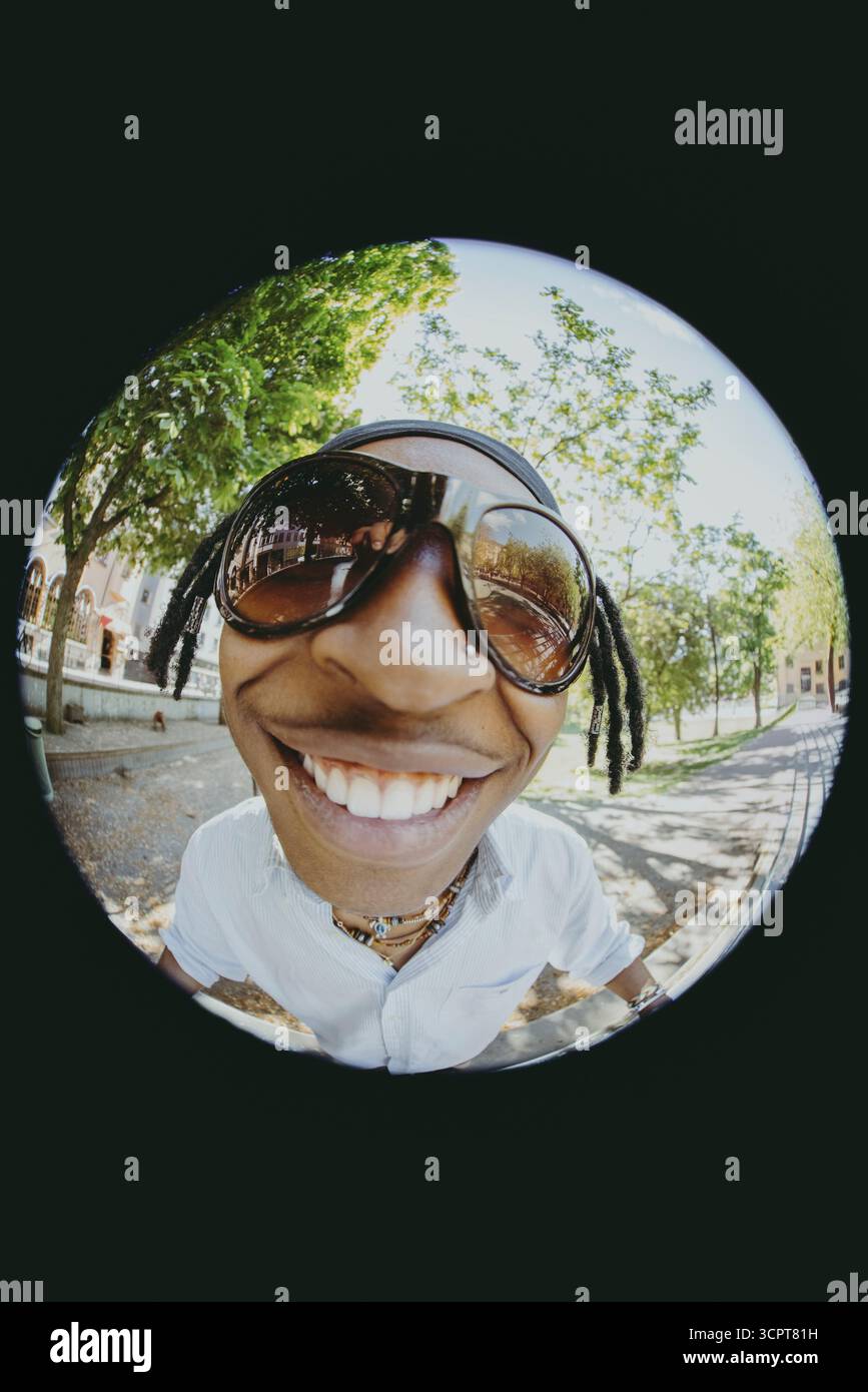 Nahaufnahme eines glücklichen, modischen jungen Mannes mit Sonnenbrille auf Fish Eye Foto Stockfoto