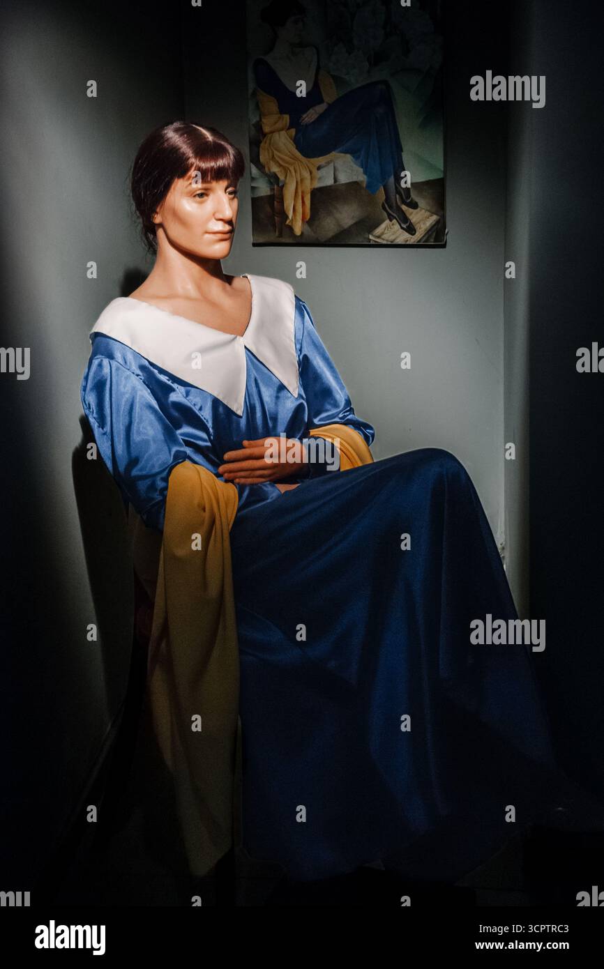 Odessa, Ukraine - 07. Januar 2014 - Wachsfigur einer Frau in blau-weißem Kleid mit gelbem Schal in schwach beleuchtetem Raum. Stockfoto