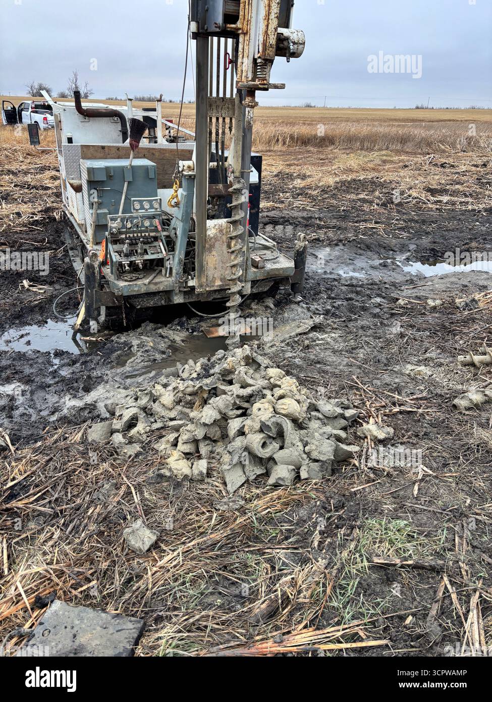Bohrfahrzeug, das Schlamm in einem schlammigen Feld absaugt. - Smartphone-aufgenommenes Stockfoto