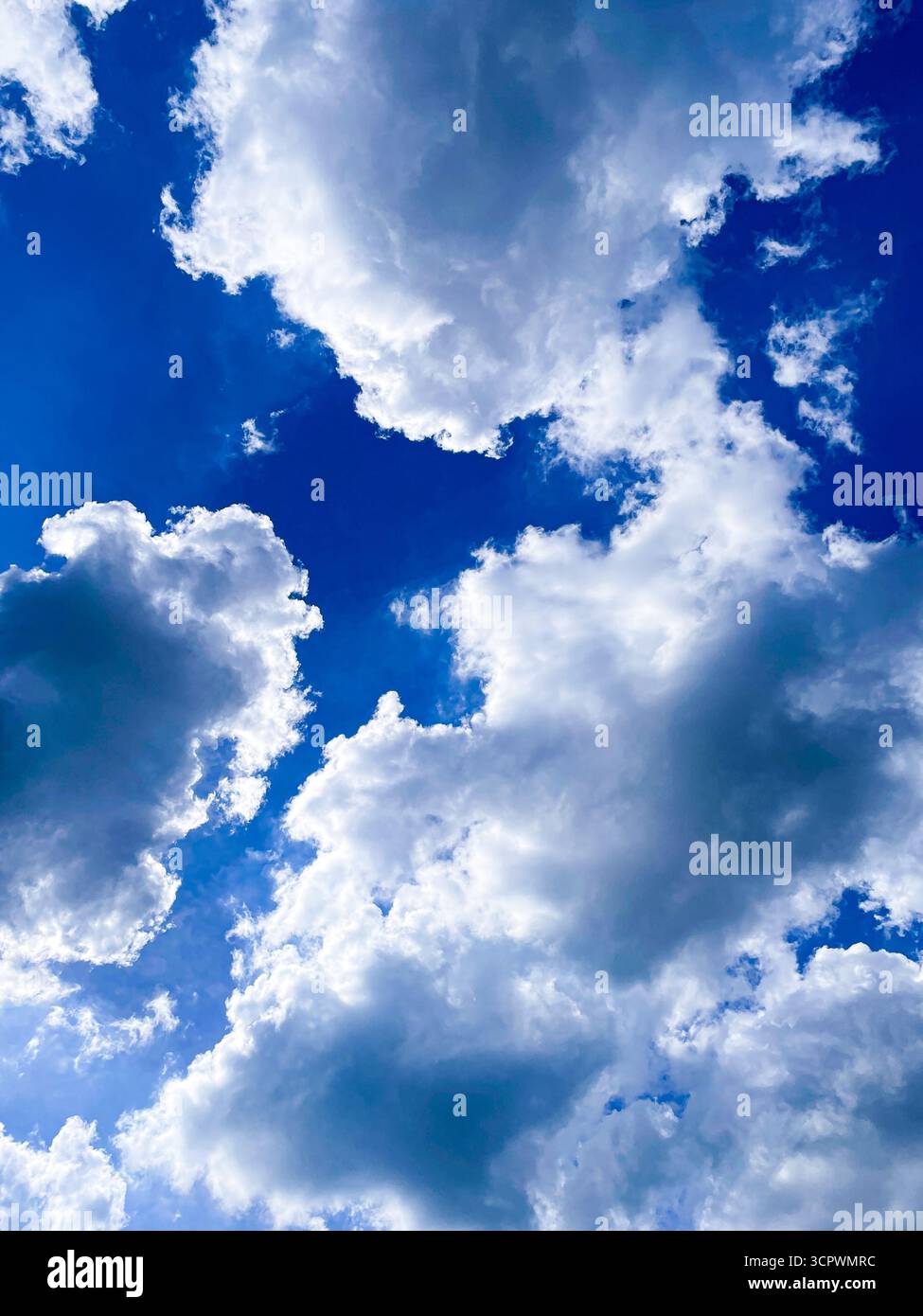 Dramatischer Himmel mit dicken Wolken gegen blauen Himmel - Smartphone-aufgenommenes Stockfoto