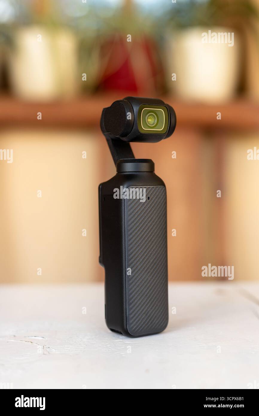 Tragbare Gimbal-Kamera auf weißem Tisch mit unscharfem Hintergrund. Stockfoto