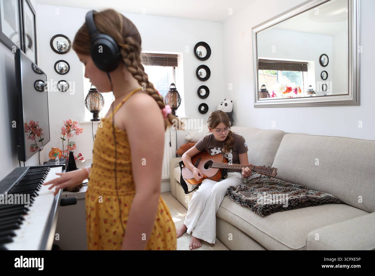 Zwei Mädchen spielen Musik zu Hause Akustikgitarre und Klavier Keyboard Stockfoto