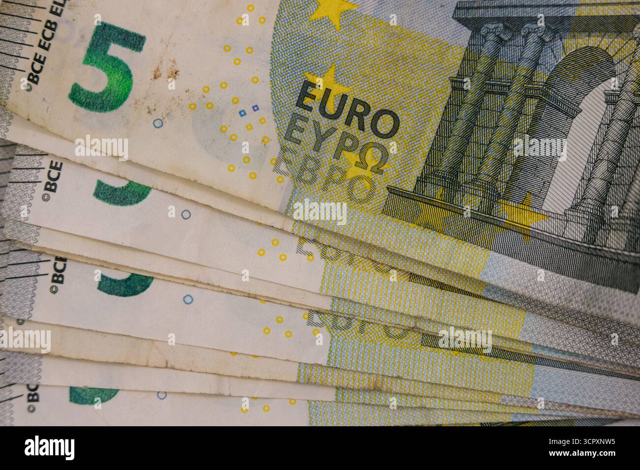 Nahaufnahme der gefächerten fünf-Euro-Banknoten. Vorherrschende Farben sind weiß, Grün, Gelb und Grau mit detaillierten architektonischen Entwürfen. Stockfoto