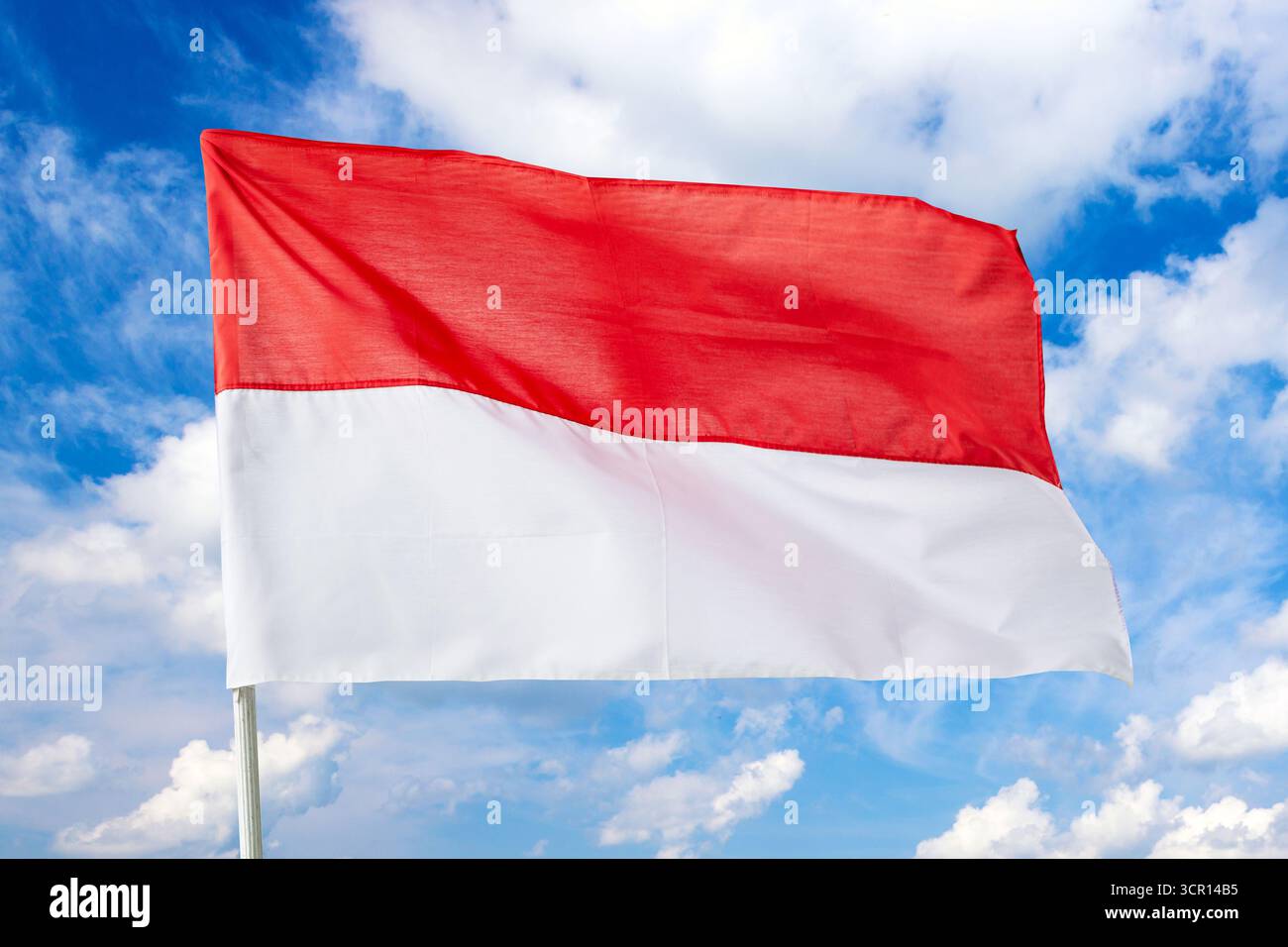 Die Republik Indonesien schwenkt die Flagge gegen den blauen Himmel. Stockfoto