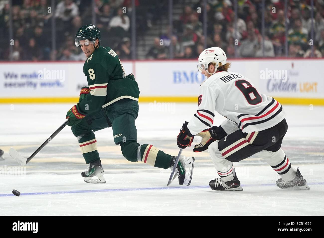 Minnesota Wild defenseman Zeev Buium (8) and Chicago Blackhawks defenseman Sam Rinzel (6) skate to the puck during the first period of an NHL hockey preseason game, Sunday, Sept. 28, 2025, in St. Paul, Minn. (AP Photo/Abbie Parr) Stockfoto