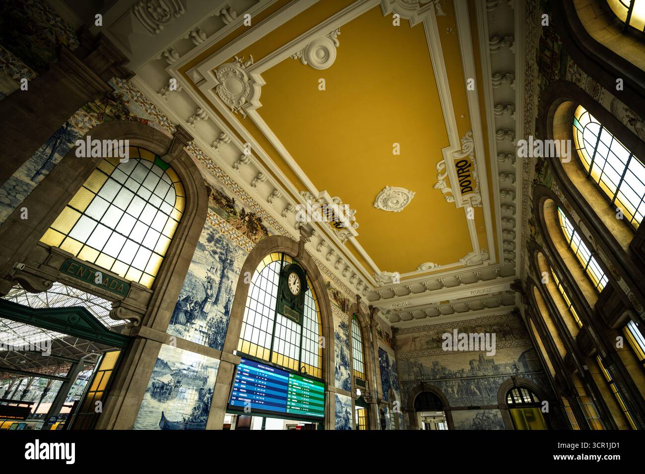 Innenansicht der Bahnhofshalle São Bento mit Uhr und Abfahrtstafel in Porto, Portugal Stockfoto