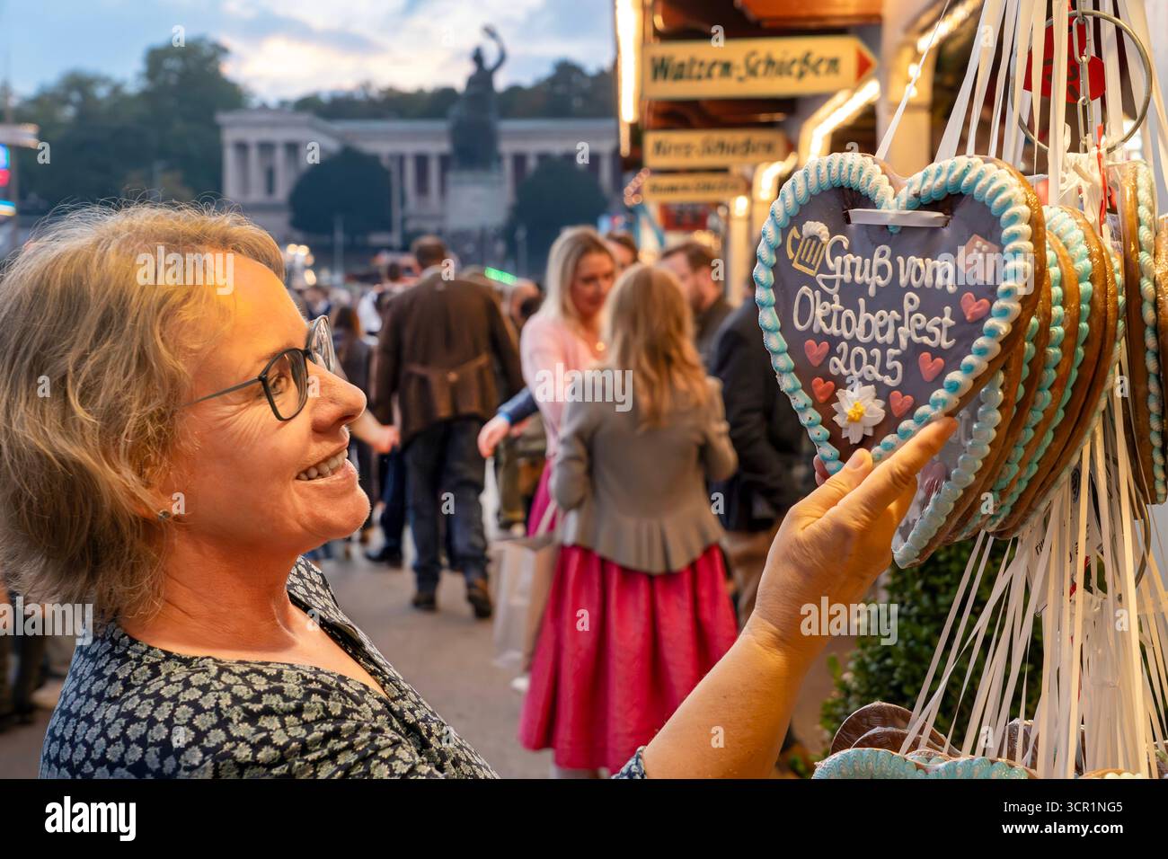 Gruß vom Oktoberfest 2025, Wiesnbesucherin mit Lebkuchenherz vor der Bavaria, Sonntagabend, ein schöner Wiesntag geht zu Ende, München, 28. September 2025 Deutschland, München, 28. September 2025, Lebkuchenherz, Gruß vom Oktoberfest 2025, Wiesnbesucherin am Lebkuchenstand, im Hintergrund die Bavaria, Sonntagabend, ein schöner Wiesntag geht zu Ende, typisch bayerisch, Volksfest, Bayern, *** Gruß vom Oktoberfest 2025, Oktoberfestbesucher mit Lebkuchenherz vor dem Bayern, Sonntagabend, ein schöner Oktoberfesttag geht zu Ende, München, 28. September 2025 Se Stockfoto
