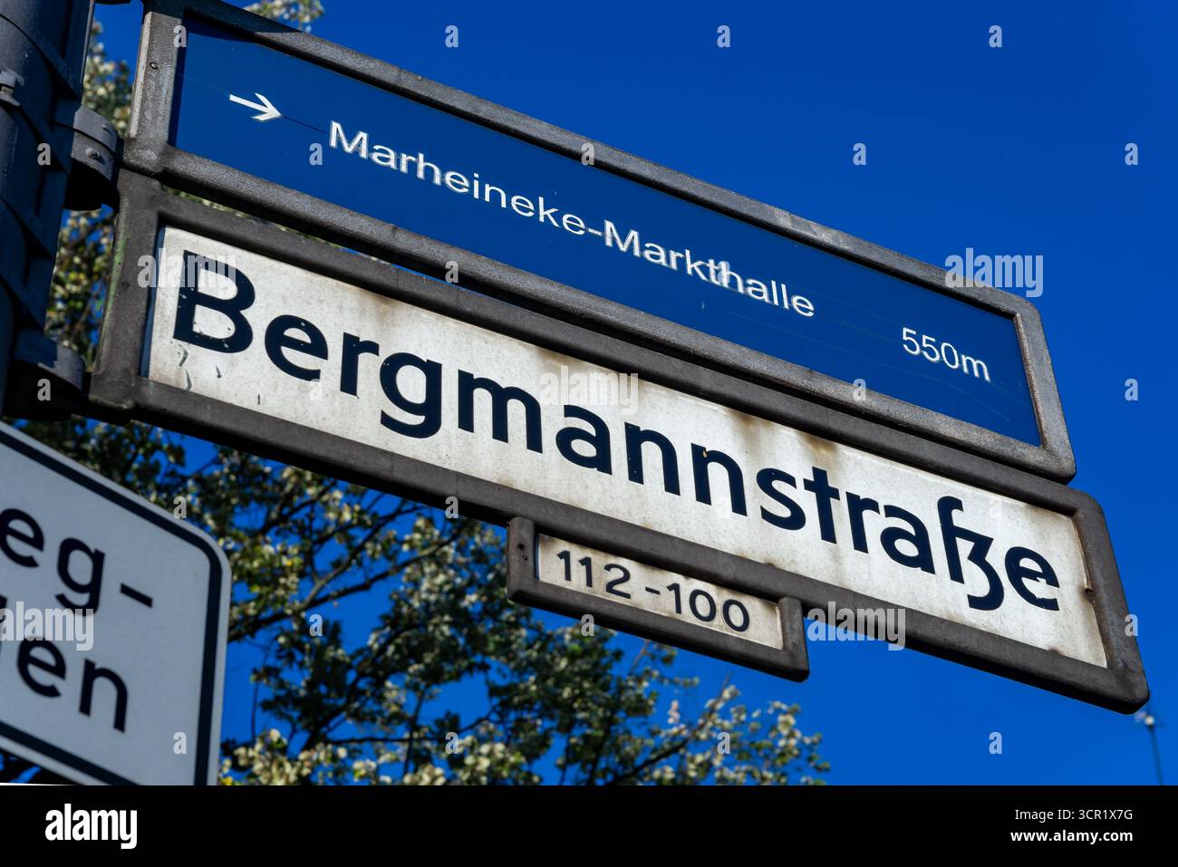 Nahaufnahme des Straßenschilds Bergmannstraße in Kreuzberg, Berlin, mit Bezug auf die nahe gelegene Marheineke Markthalle. Stockfoto