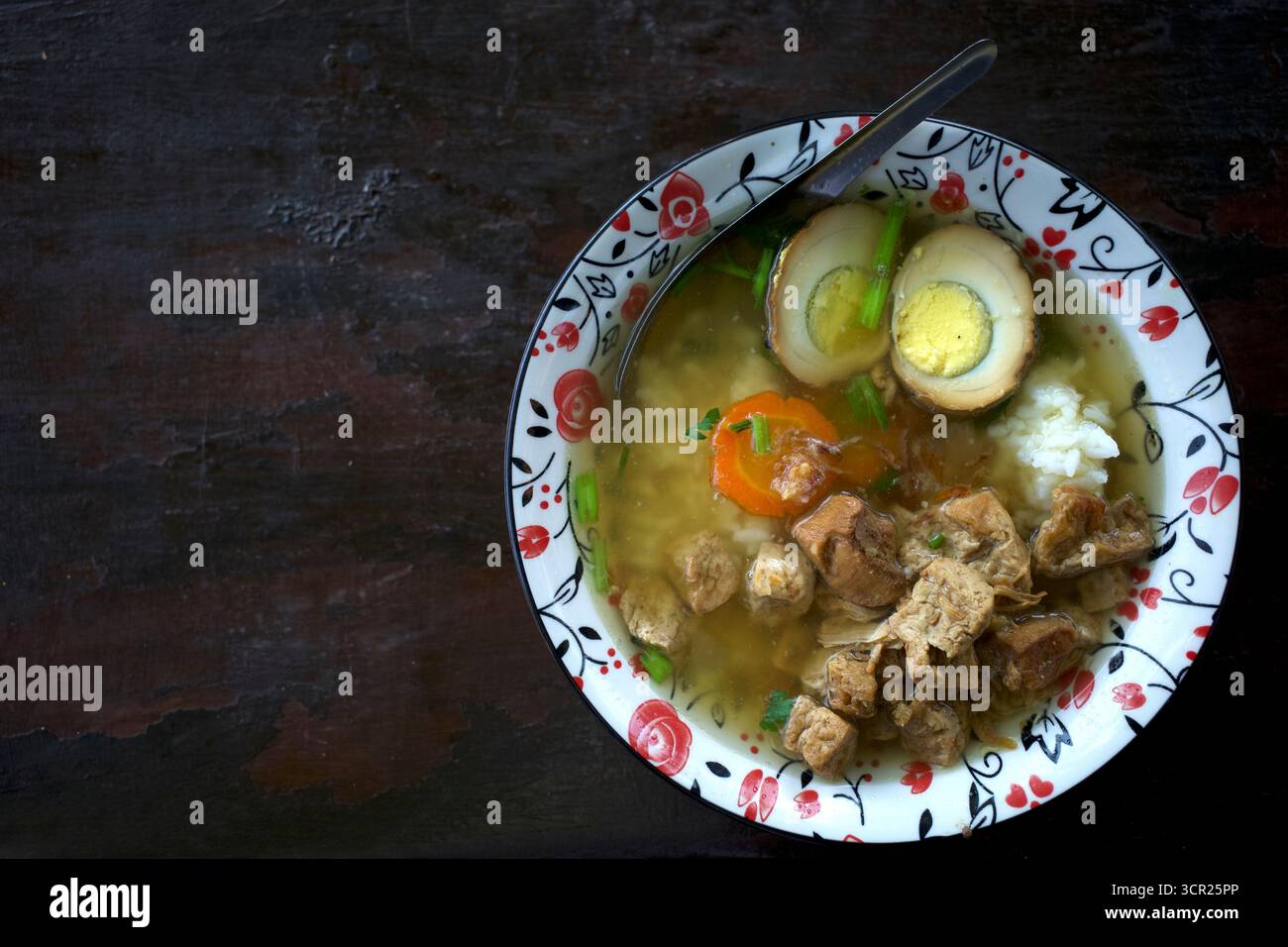 Nasi Bakmoy, ein indonesisches Reisgericht mit chinesischen kulinarischen Einflüssen, mit weißem Reis, garniert mit herzhaftem Huhn, gebratenem Tofu in Würfel und einem gekochten Ei. Stockfoto