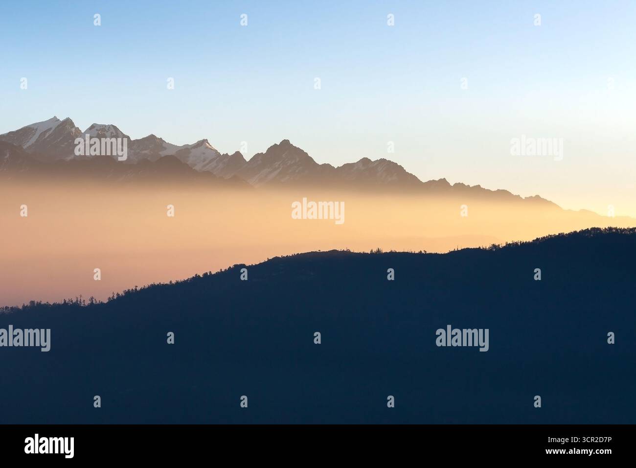 Fantastische Berglandschaft bei Sonnenaufgang im Himalaya, Nepal. Neblige Bergkulisse mit hohen Gipfeln im Hintergrund. Stockfoto