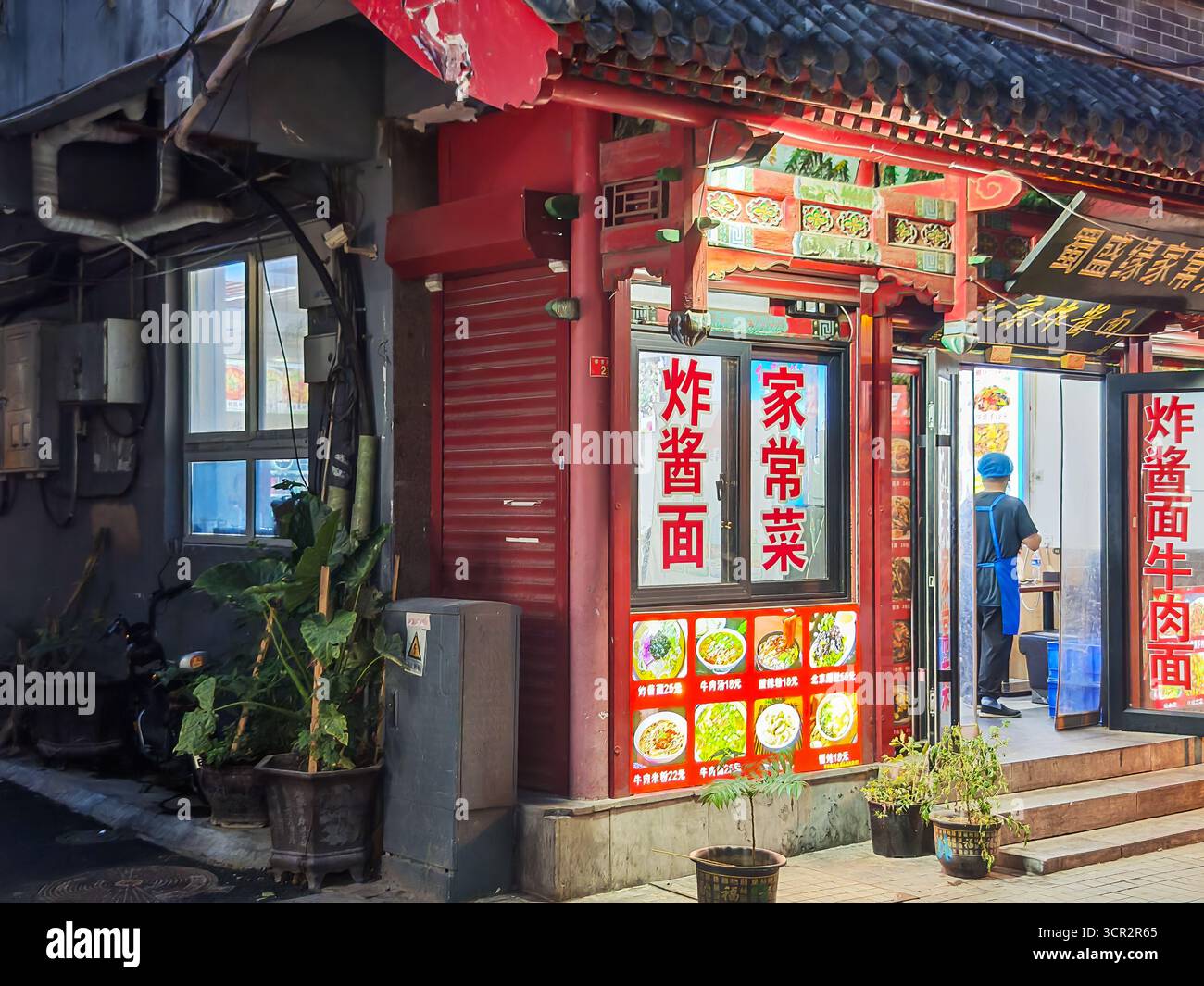 Peking, China - 15. September 2025 : lebendiges, rotes traditionelles Restaurant, das eine lebhafte Straße in Pekings Qianmen-Gegend beleuchtet und lokale Küche mit einheimischen Gerichten serviert Stockfoto