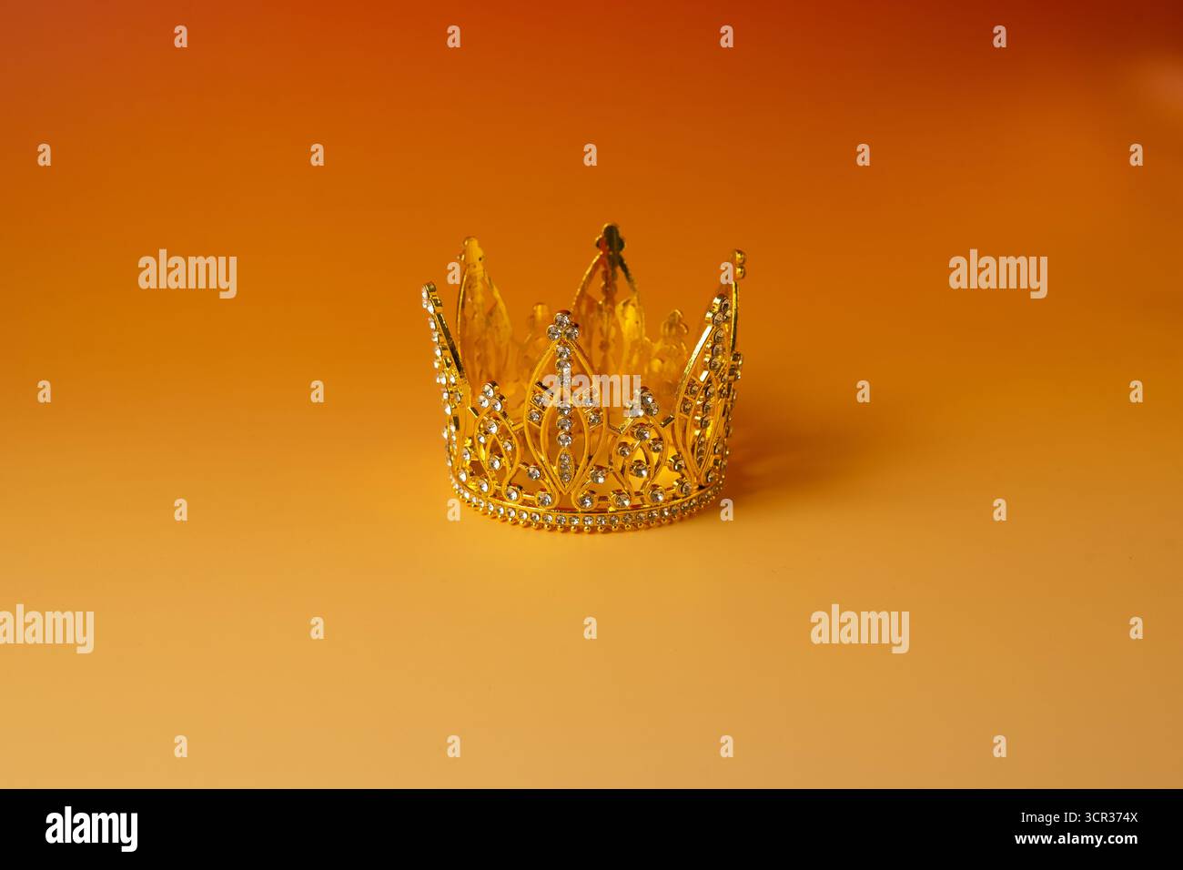 Goldene Krone auf orangefarbenem Hintergrund Stockfoto