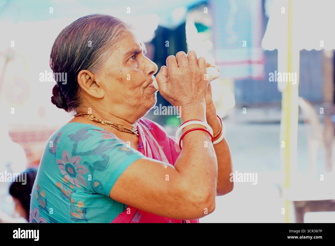 Dhaka, Dhaka, Bangladesch. September 2025. Mit der Ankunft des Herbstes in Bengalen läutet der Duft der Sheuli-Blüten das Aufkommen von Durga Puja ein. Der Rhythmus des Dhak, der Klang der Muschel und die frische Verzierung der Natur schaffen zusammen eine festliche Atmosphäre. Am 29. September 2025, dem Tag von Maha Saptami, konnte man bei der Überquerung von schlammigen Straßen und einer provisorischen Brücke aus Betelnussbäumen eine einzigartige ländliche Feier von Durga Puja im Boral Bari im Dorf Swarupkathi erleben. Mit bunten Blumen, den Takten des Dhak und der anmutigen Teilnahme von Dorffrauen, der Anbetungskredit Stockfoto