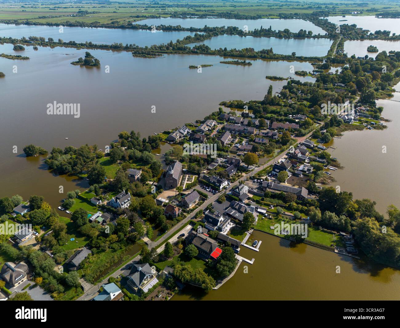 Blick aus der Vogelperspektive auf eine Wohngegend am See mit privaten Docks, grünen Rasenflächen und ruhigem Wasser. Das Layout spiegelt eine friedliche Gemeinschaft wider, die an das Wasser angepasst ist Stockfoto