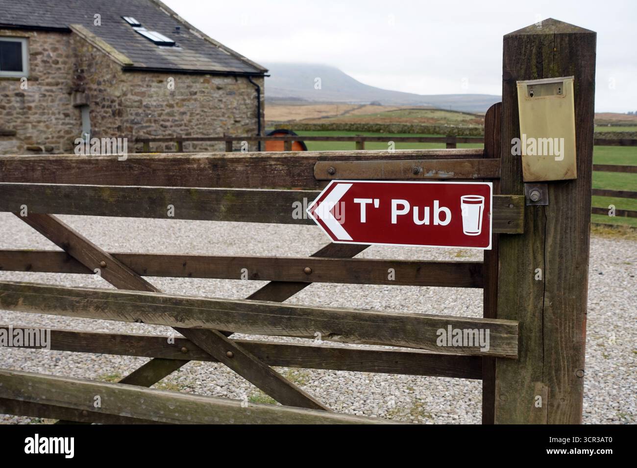 Wooden Sign to the Pub in der Nähe des Ribblehead Railway Viaduct am 3 Peaks Trail, Ribblesdale, Yorkshire Dales National Park, Yorkshire, England, Großbritannien. Stockfoto