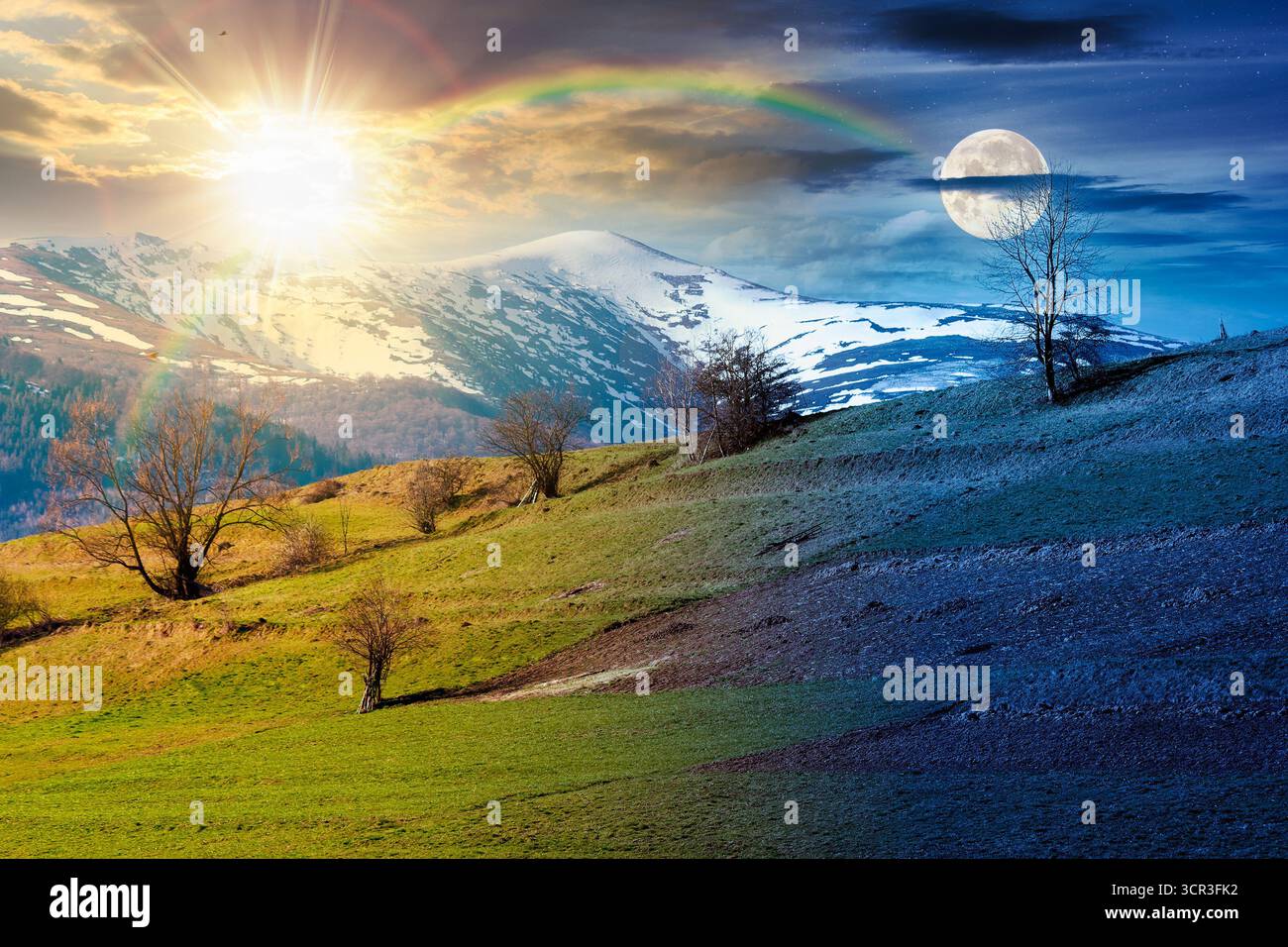 Berglandschaft am Frühlingsnachtgleiche. Tag- und Nachtzeit ändern sich. Grasbewachsenes Feld am Hang eines Hügels. Bergrücken mit schneebedeckten Spitzen Stockfoto