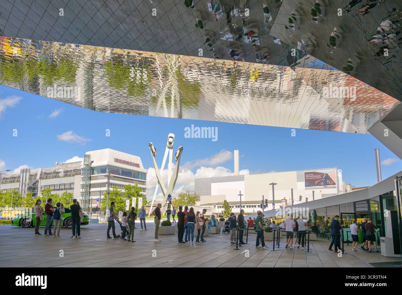 Stuttgart, Deutschland - 22. August 2024: Besucher erkunden modernes Design und klassische Sportwagen, während sie einen sonnigen Tag in Stuttgart genießen. Stockfoto