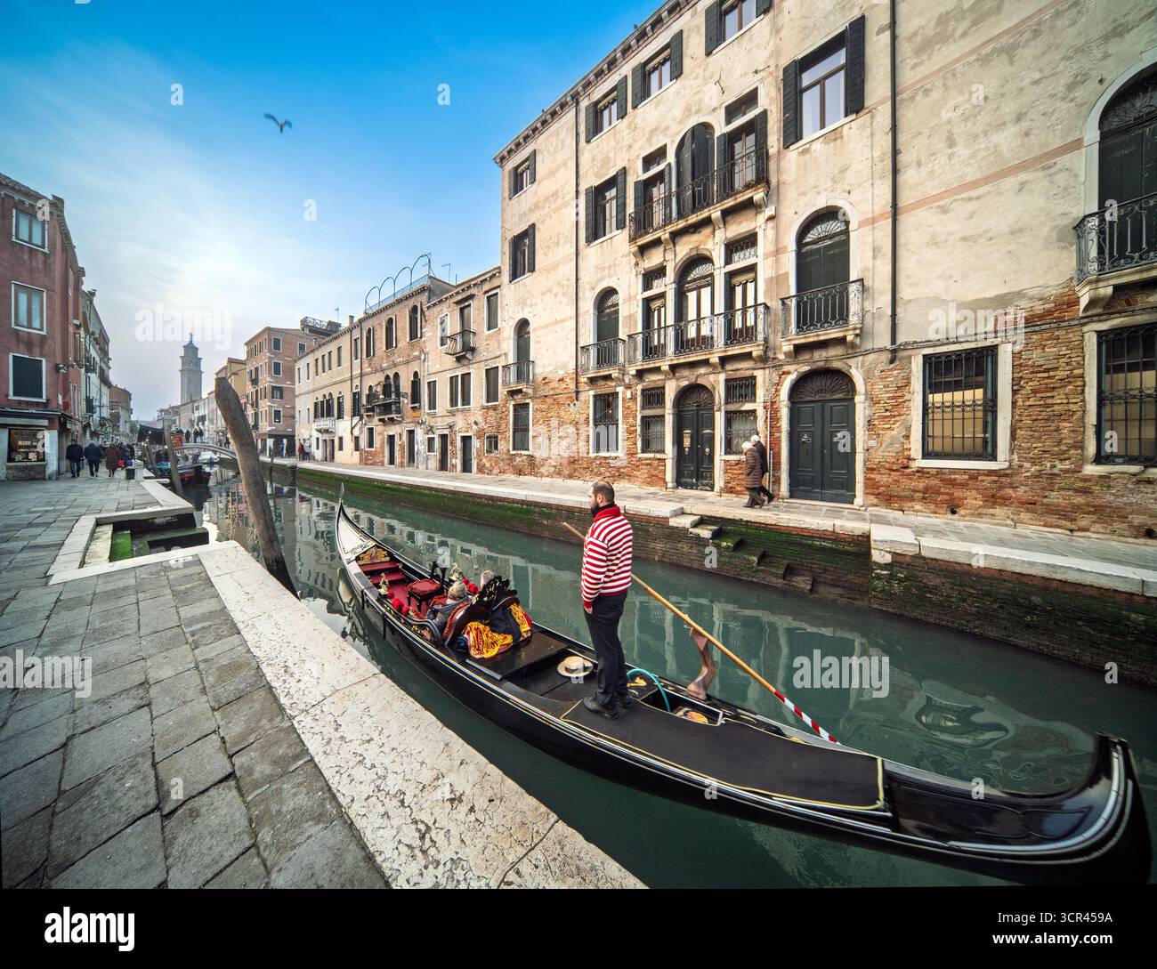 Rio San Barnaba, Venedig. Gondeln gleiten vorbei an verwittertem Ziegelstein und klassischem Stein – Dorsoduros ruhiger Kanal, wo Obstkähne anlegen und Schatten verweilen Stockfoto