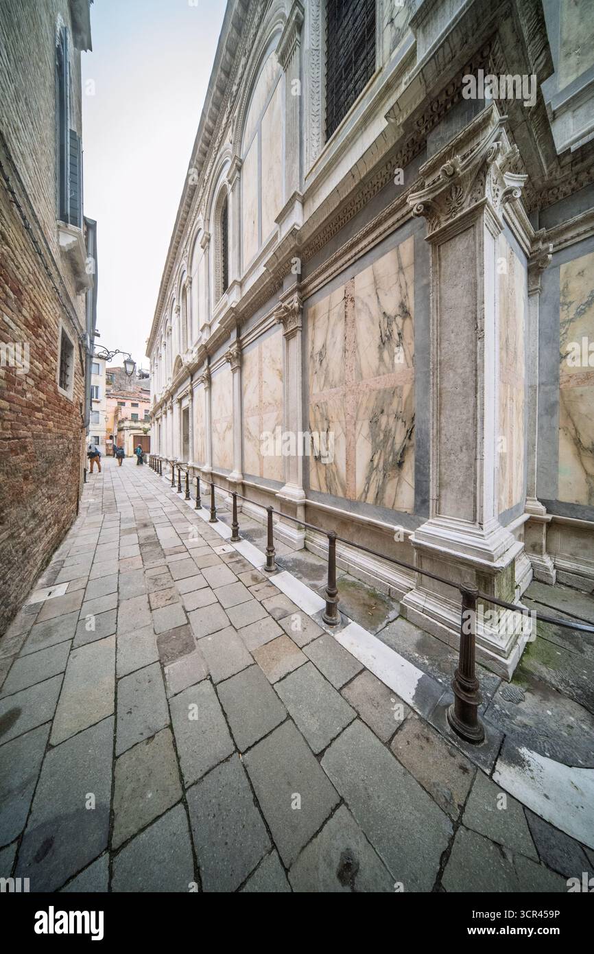 Die ruhige Gasse in Venedig zeigt den leuchtenden polychromen Marmor von Santa Maria dei Miracoli mit korinthischen Pilastern und kunstvoll geschnitzten Tafeln Stockfoto