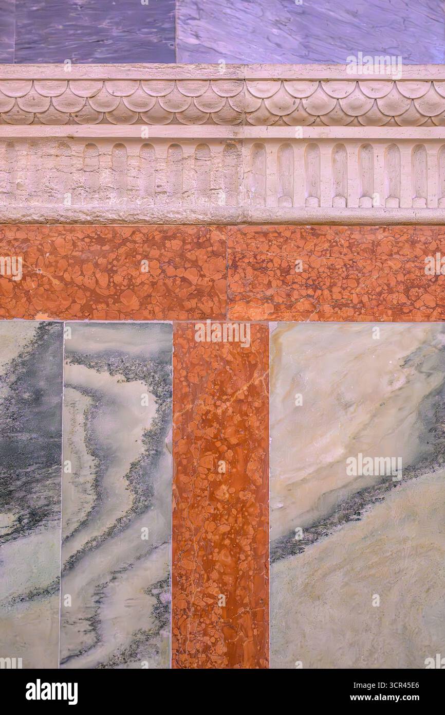 Polychrome Marmorpaneele schaffen geometrische Muster unter geschnitzten Friesen in einem atemberaubenden Wanddetail in Santa Maria dei Miracoli, Cannaregio, Venedig. Stockfoto
