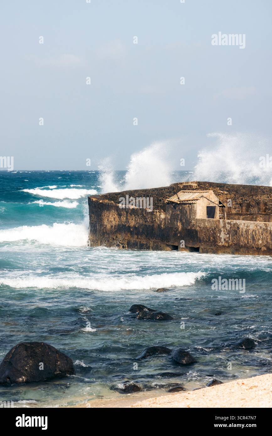 Wellen stoßen an einer felsigen Küste unter klarem Himmel gegen eine alte Steinstruktur. Phu Quy Island, Bnh Thuan, Vietnam Phu Quy Island, Bnh Thuan, Vietnam Stockfoto