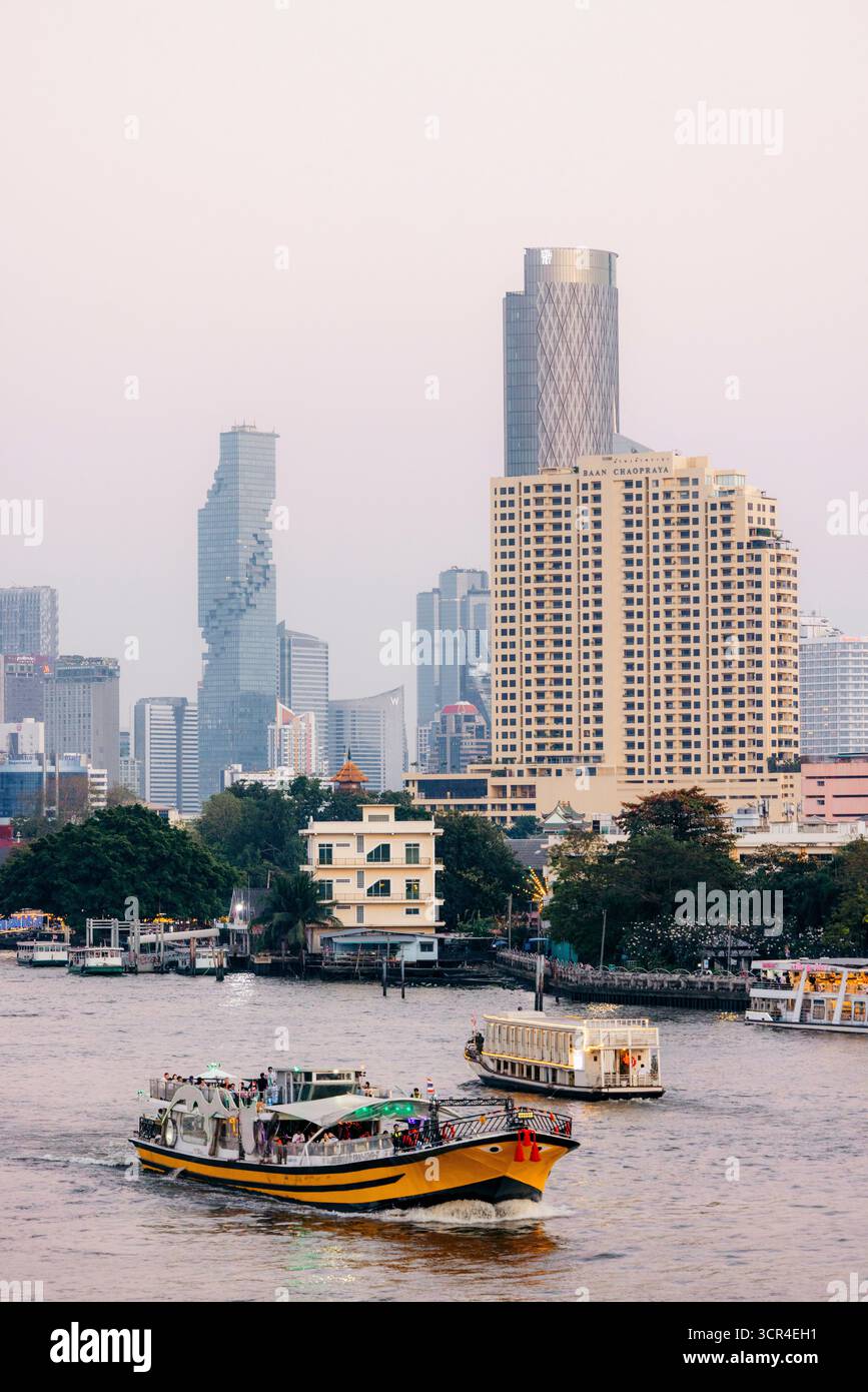 Der geschäftige Fluss mit Booten vor der Skyline der Stadt während des Tages. Chao Phraya River, Bangkok, Thailand Stockfoto