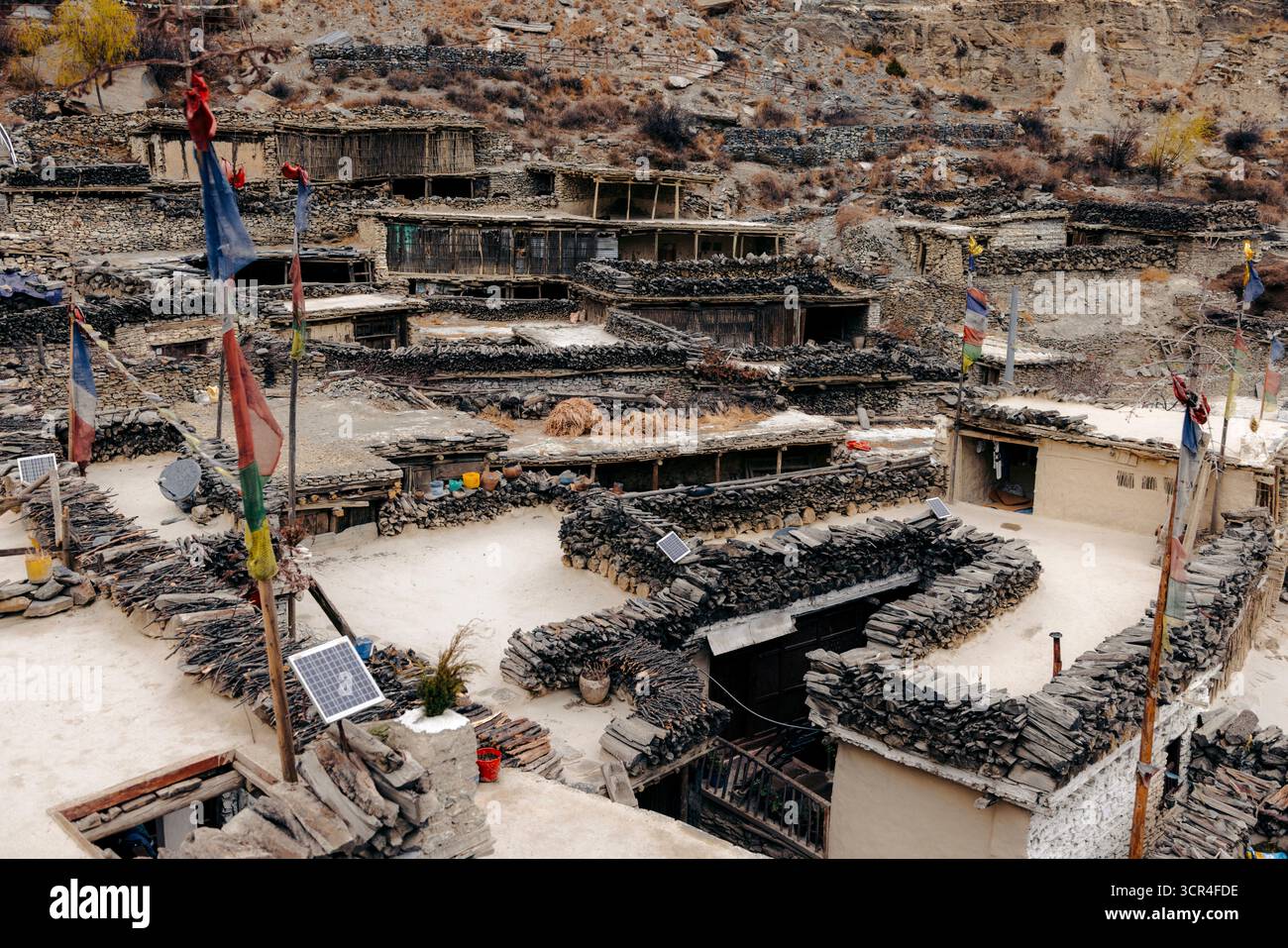 Ein rustikales Bergdorf mit Steinbauten und bunten Gebetsfahnen auf Dächern. Marpha, Annapurna, Bezirk Mustang der Provinz Gandaki, Nepal Stockfoto