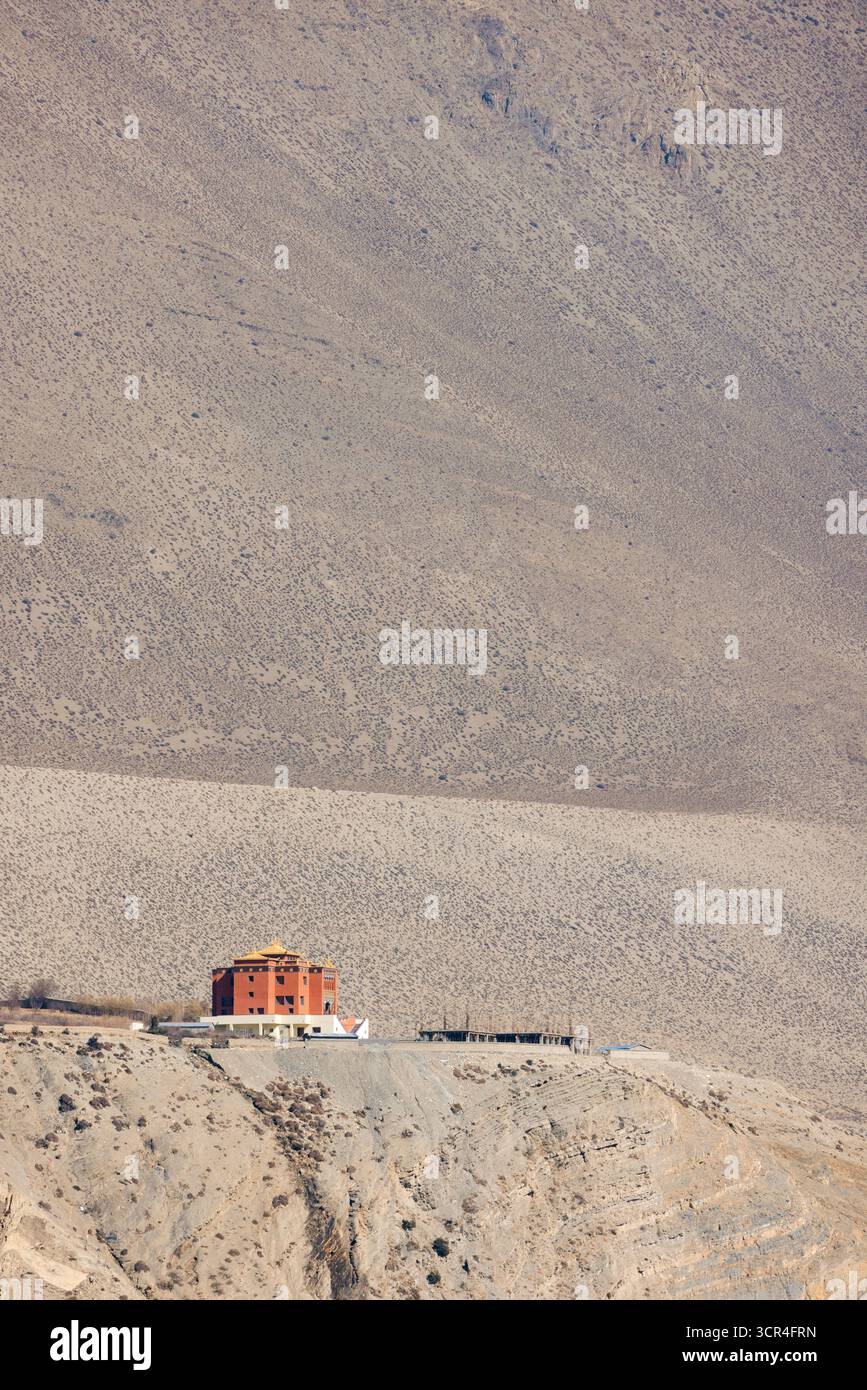 Abgelegenes Wüstengebäude vor einer riesigen Bergkulisse. F042, Annapurna, Mustang District, Provinz Gandaki, Nepal Stockfoto